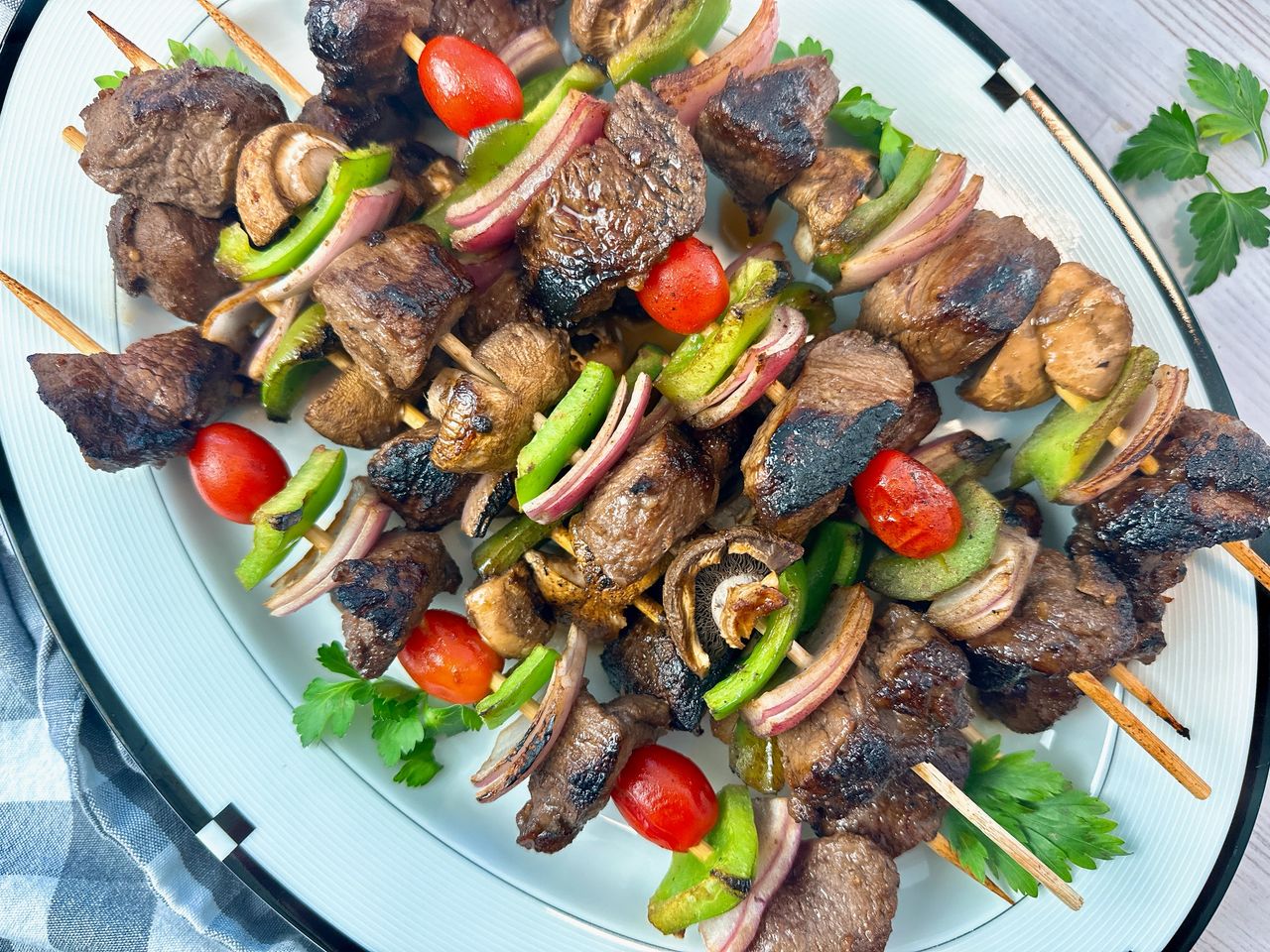 beef and vegetable kebabs on a white serving plate