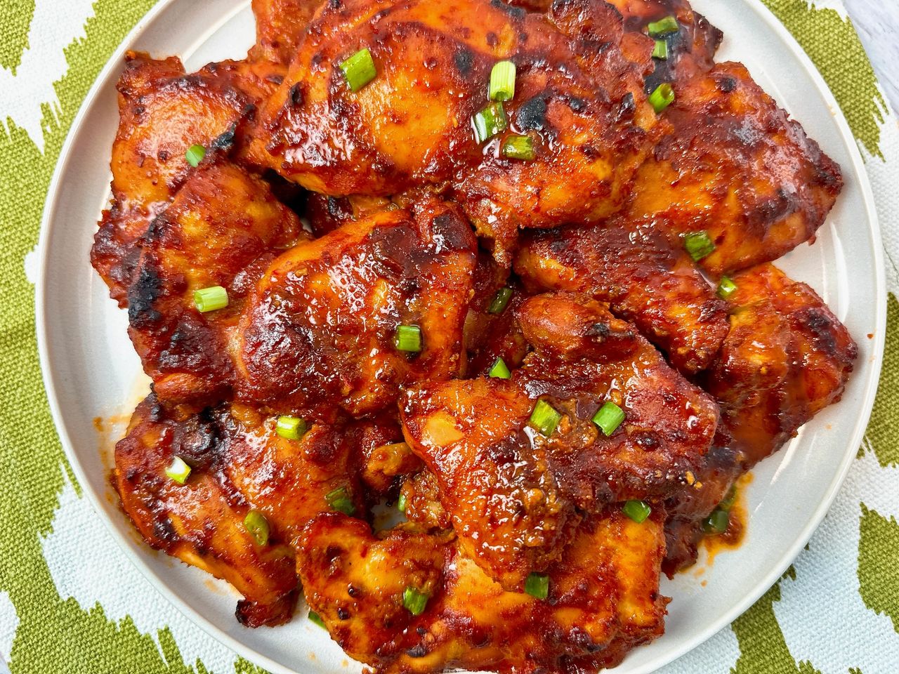Sheet Pan Gochujang Chicken gochujang chicken thighs on a white plate