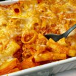 pasta and sausage in a casserole dish and white bowl
