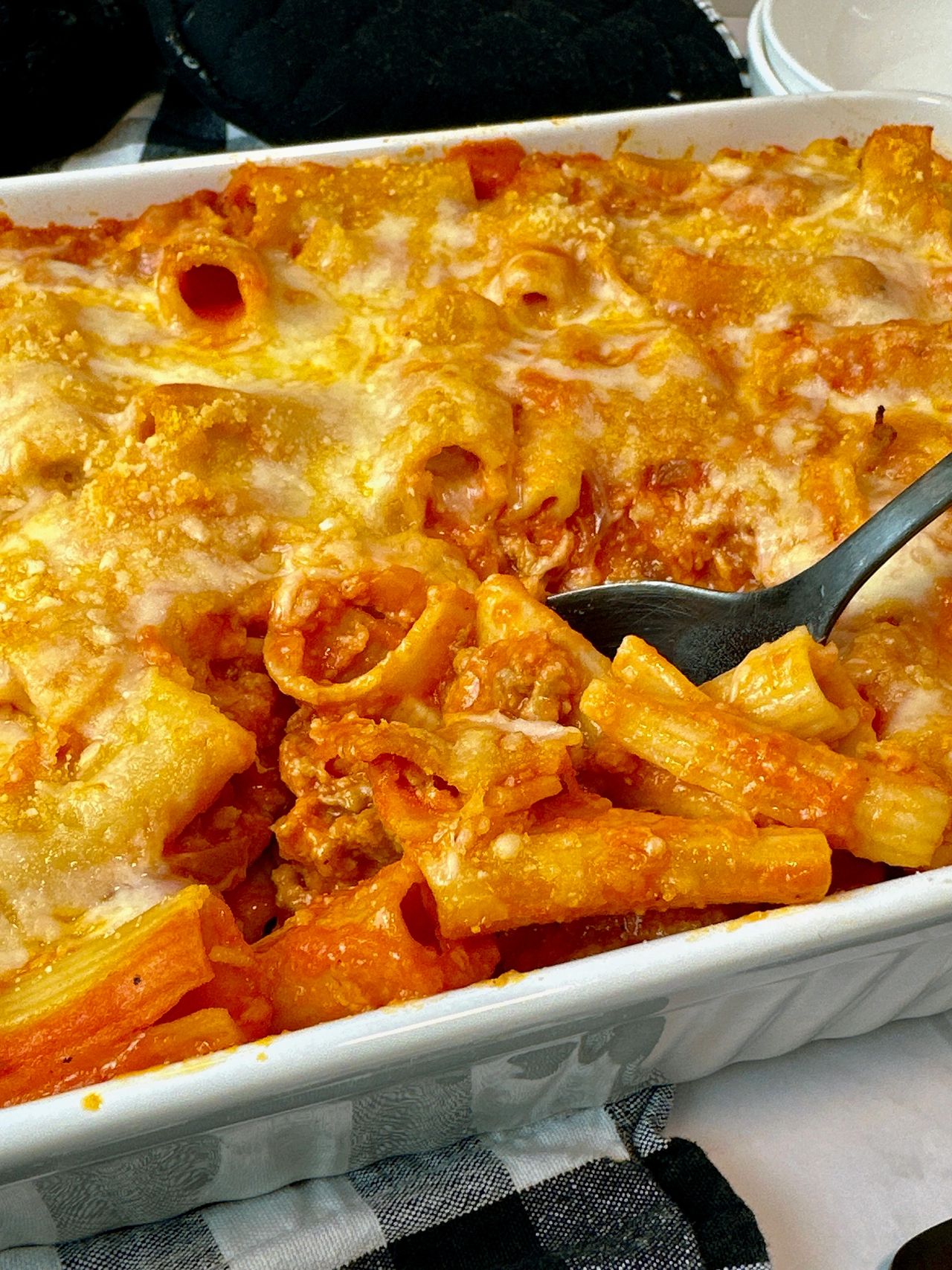 pasta and sausage in a casserole dish and white bowl