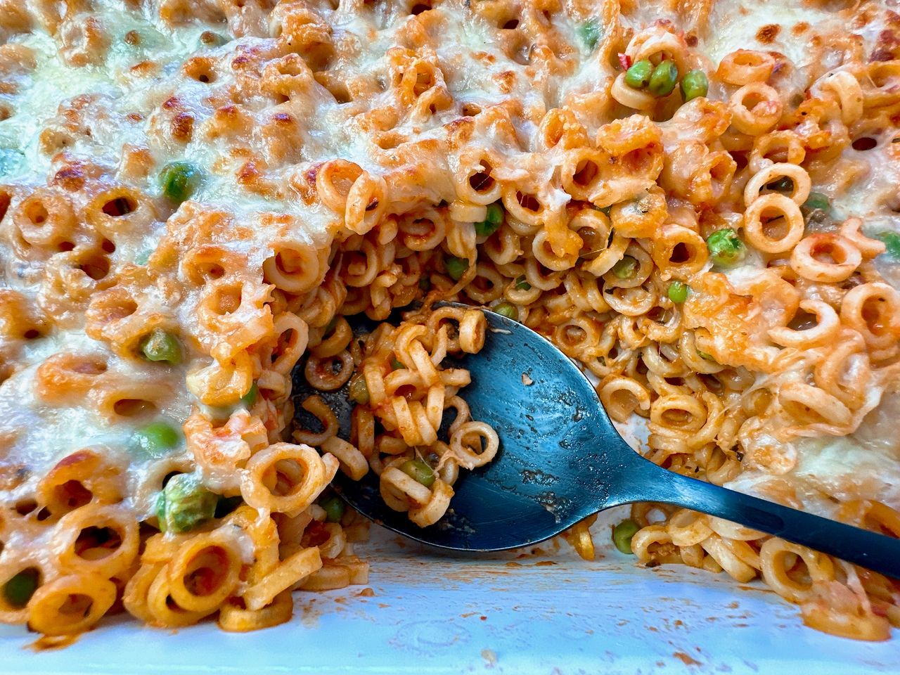 Baked Spaghetti Rings baked pasta rings with sauce and cheese in a white casserole dish