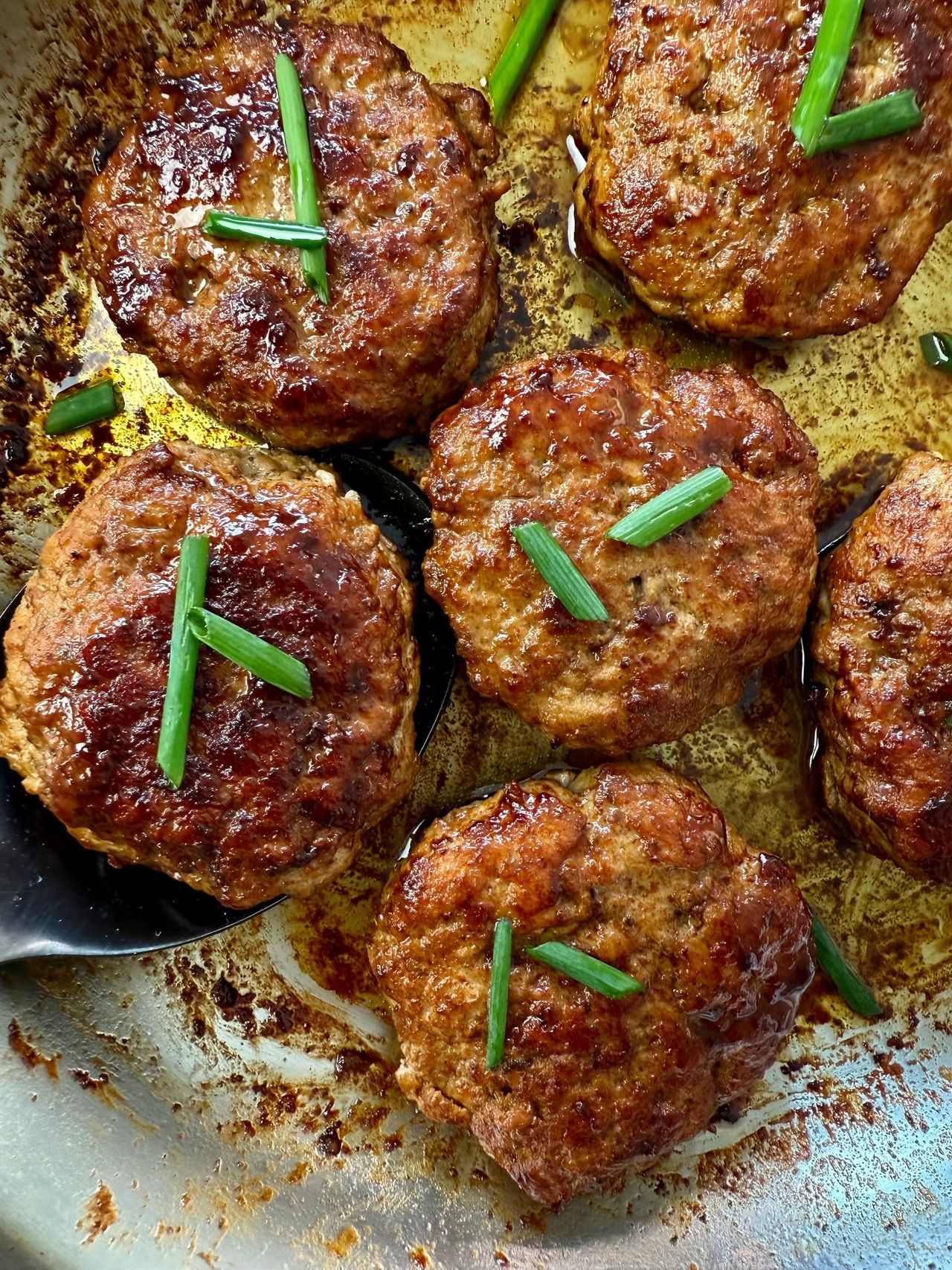 polish sausage on a spoon in a skillet