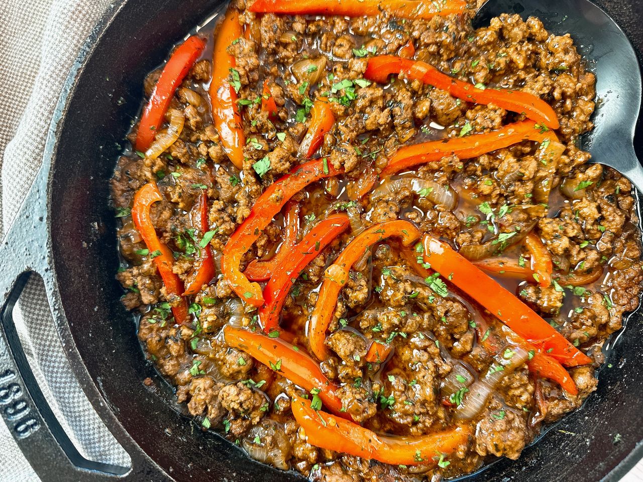 ground beef and peppers in a cast iron skillet