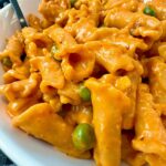 pasta and peas in a white bowl