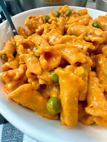 pasta and peas in a white bowl