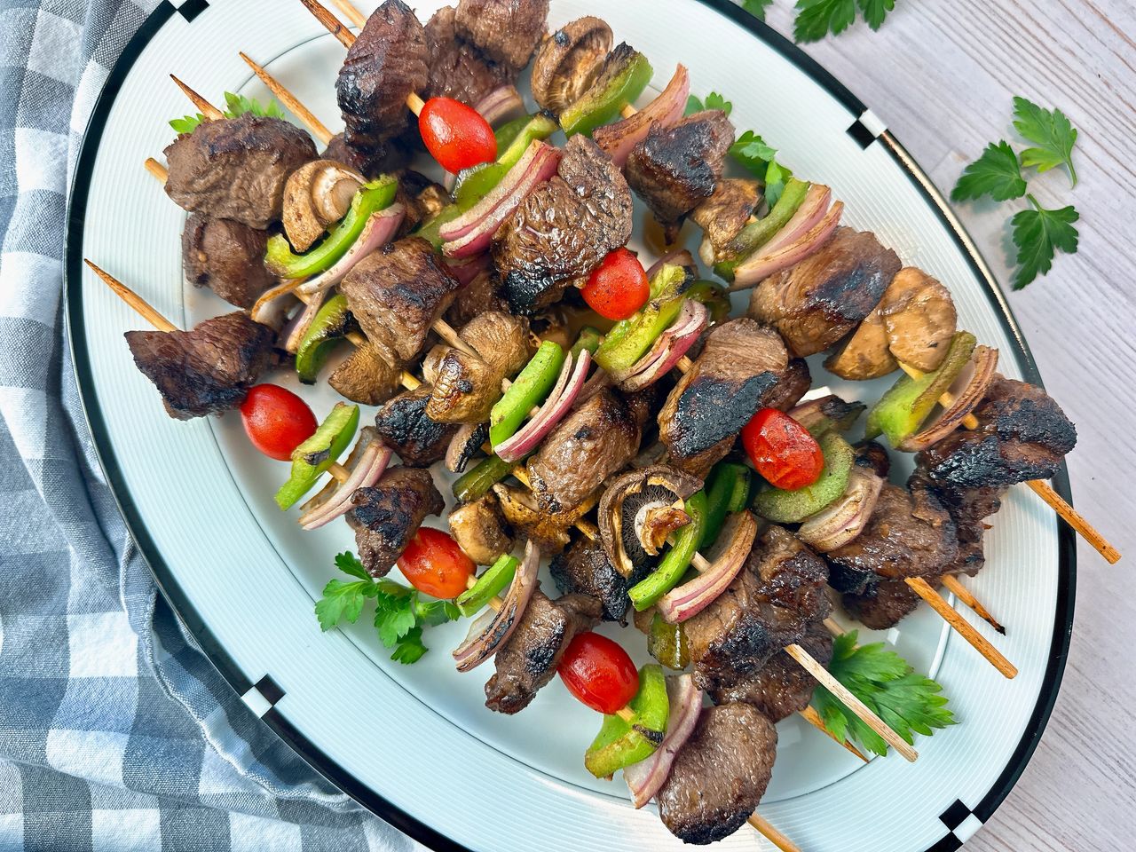 Wagyu Beef Kebabs beef and vegetable kebabs on a white serving plate