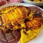 saffron chicken and red onion on a white plate