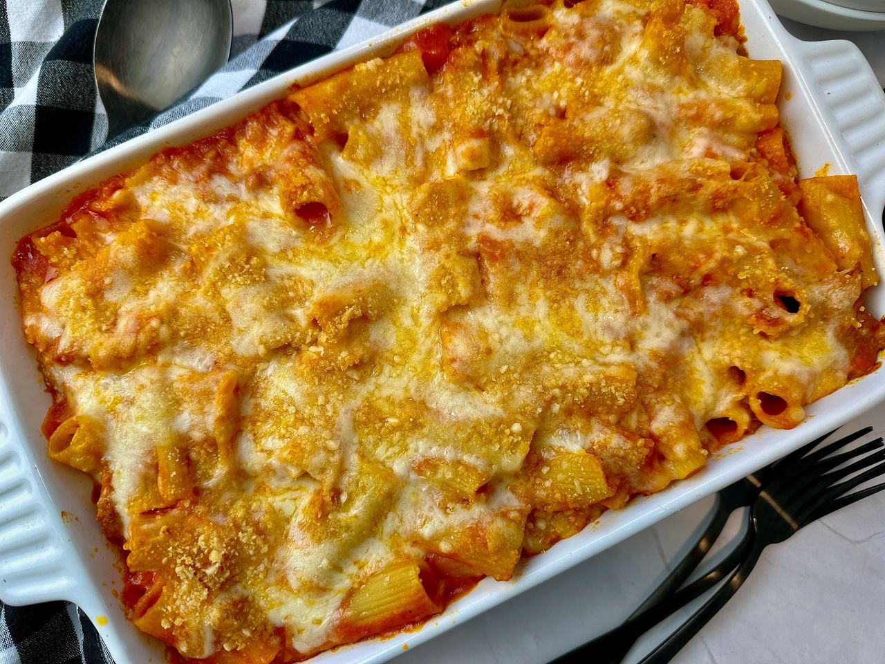 pasta and sausage in a casserole dish and white bowl
