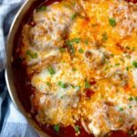 chicken thighs and marinara sauce with cheese in a pan