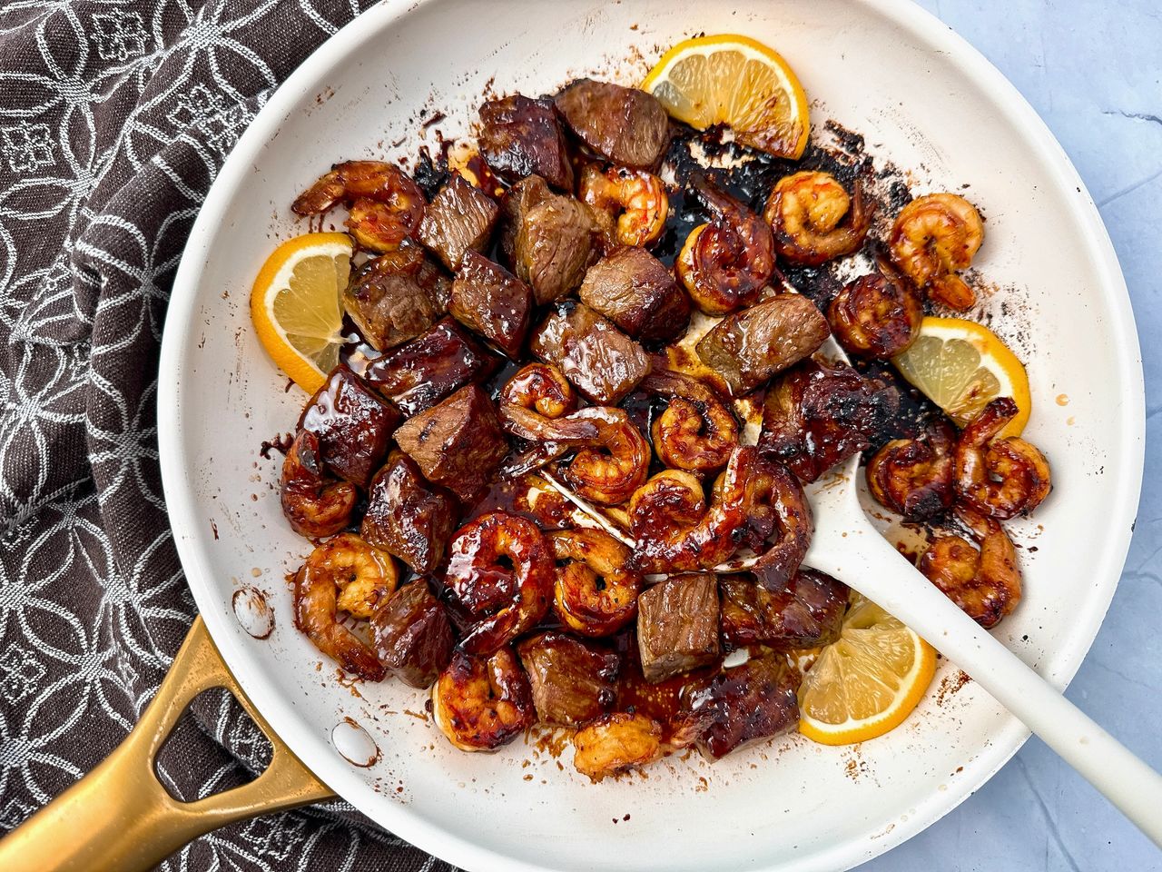 steak and shrimp in a white skillet