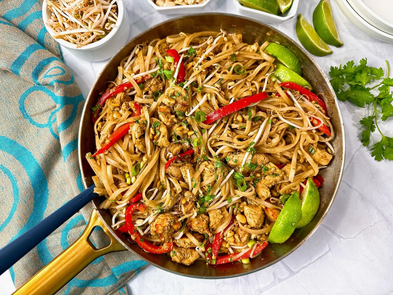 Pad Thai pad thai in a silver skillet with peanuts on the side