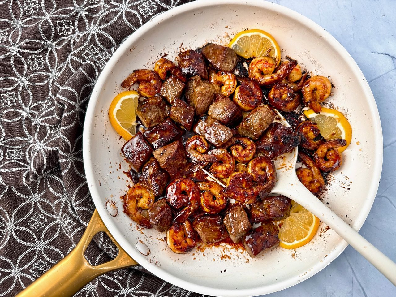 steak and shrimp in a white skillet