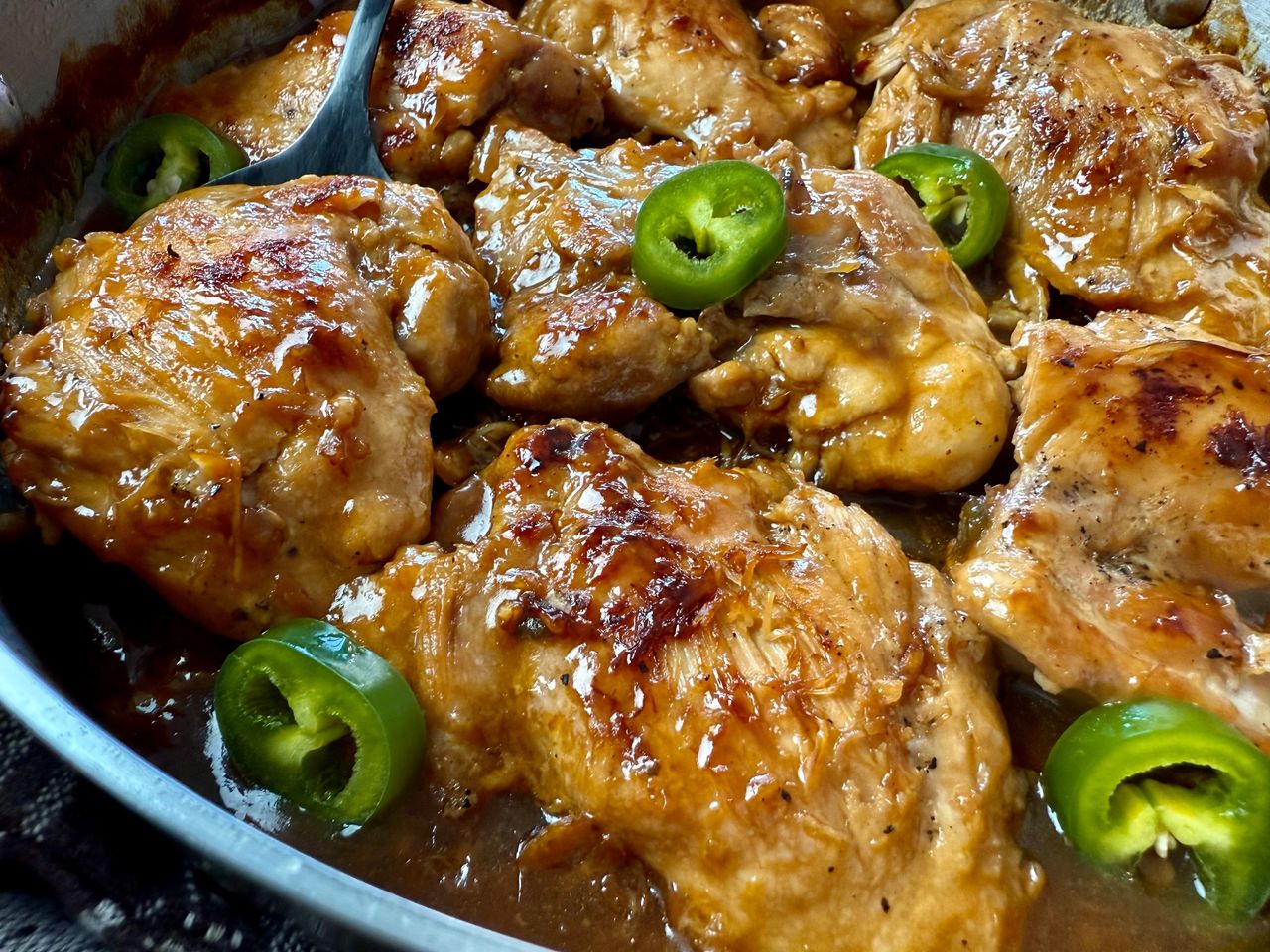 chicken thighs and jalapeno peppers in a silver pan