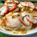 baked chicken with cheese and tomatoes on a white plate