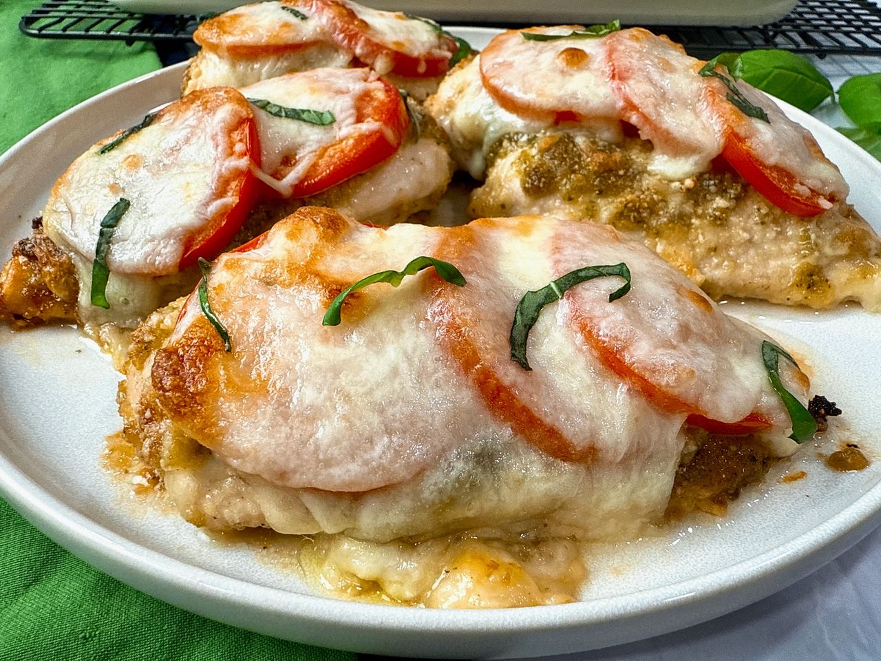 baked chicken with cheese and tomatoes on a white plate