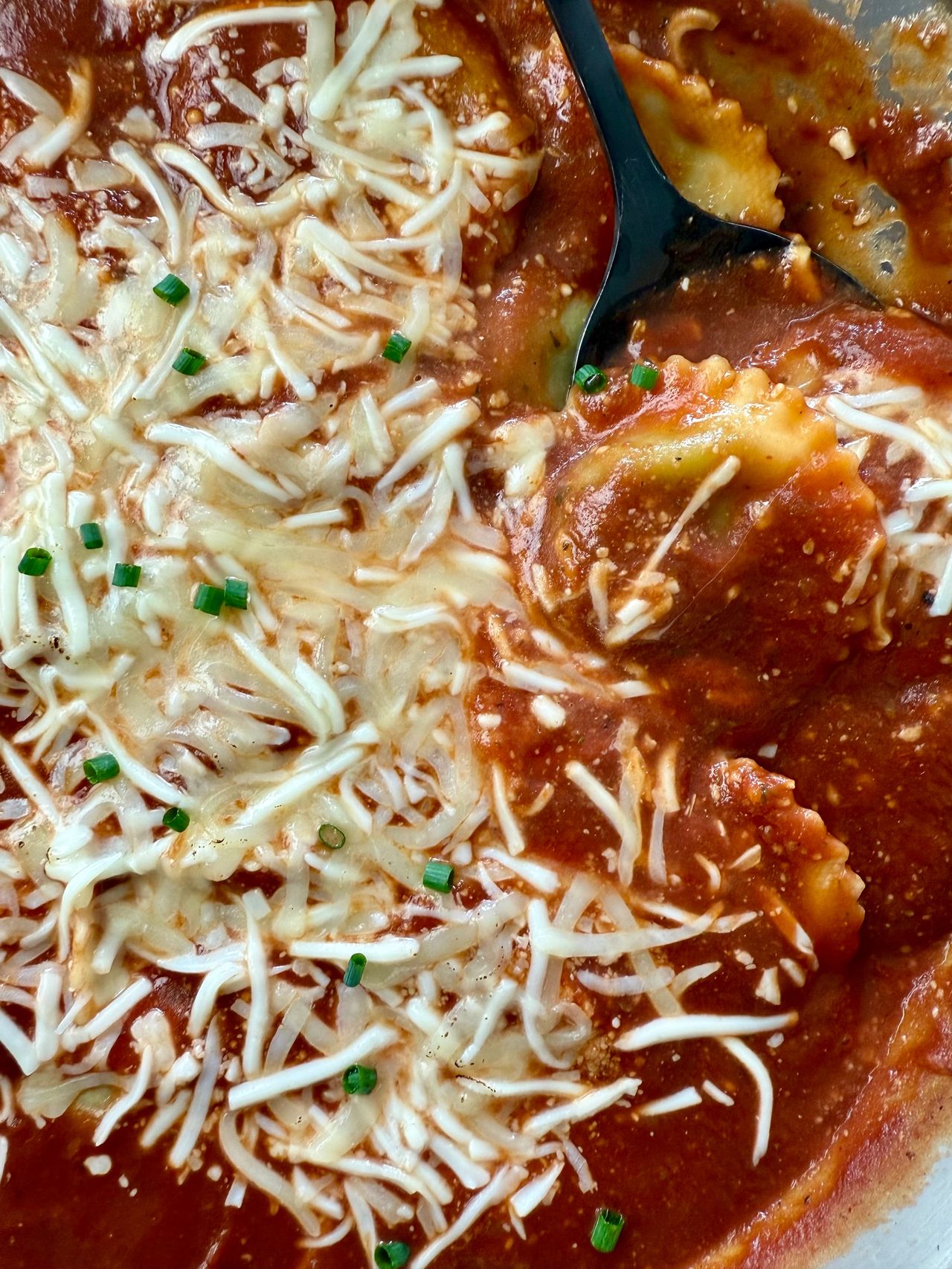 spinach ravioli and marinara sauce with mozzarella cheese