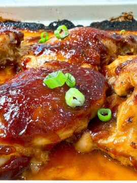 Chicken thighs on a baking sheet with a teriyaki glaze.
