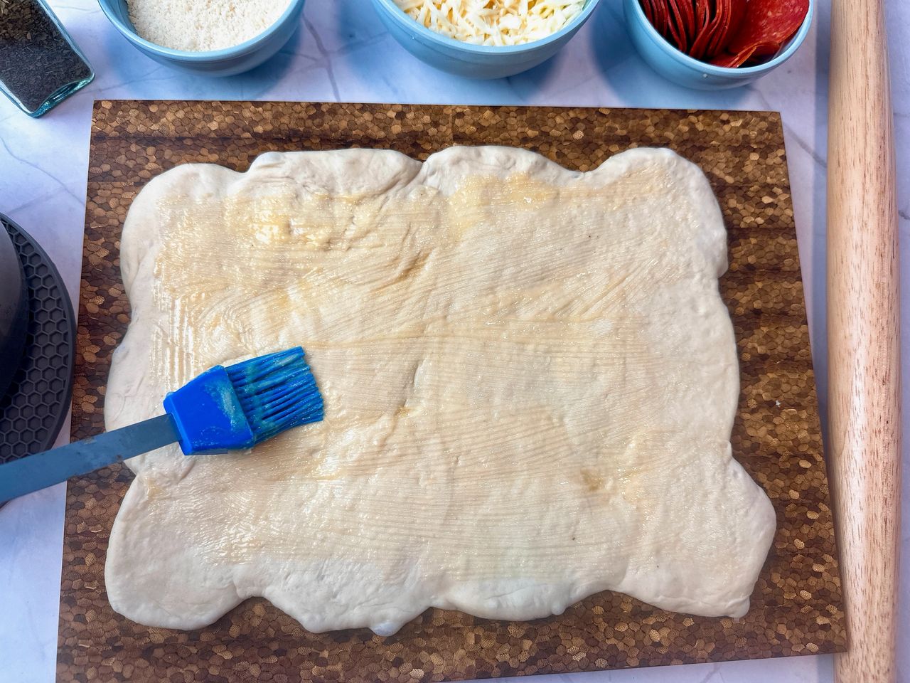 brushing bread dough with butter
