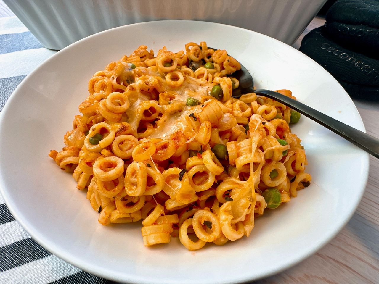baked pasta rings with sauce and cheese on a white plate