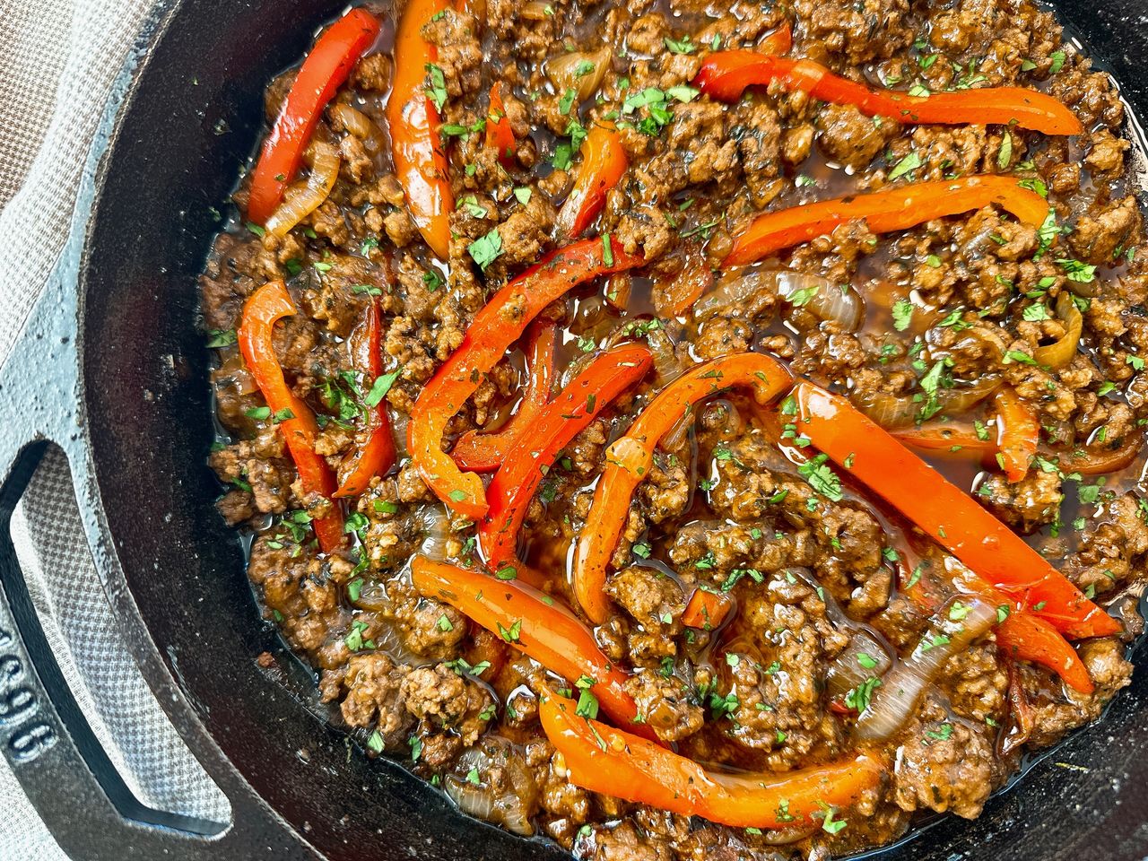 ground beef and peppers in a cast iron skillet