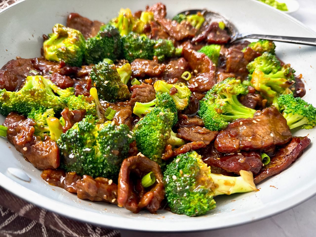 beef and broccoli in a white skillet