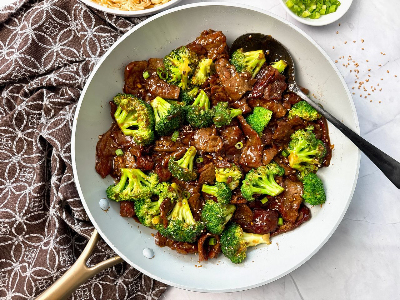 beef and broccoli in a white skillet