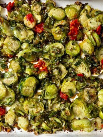 Shaved Brussels Sprouts with Calabrian Peppers on a white baking pan