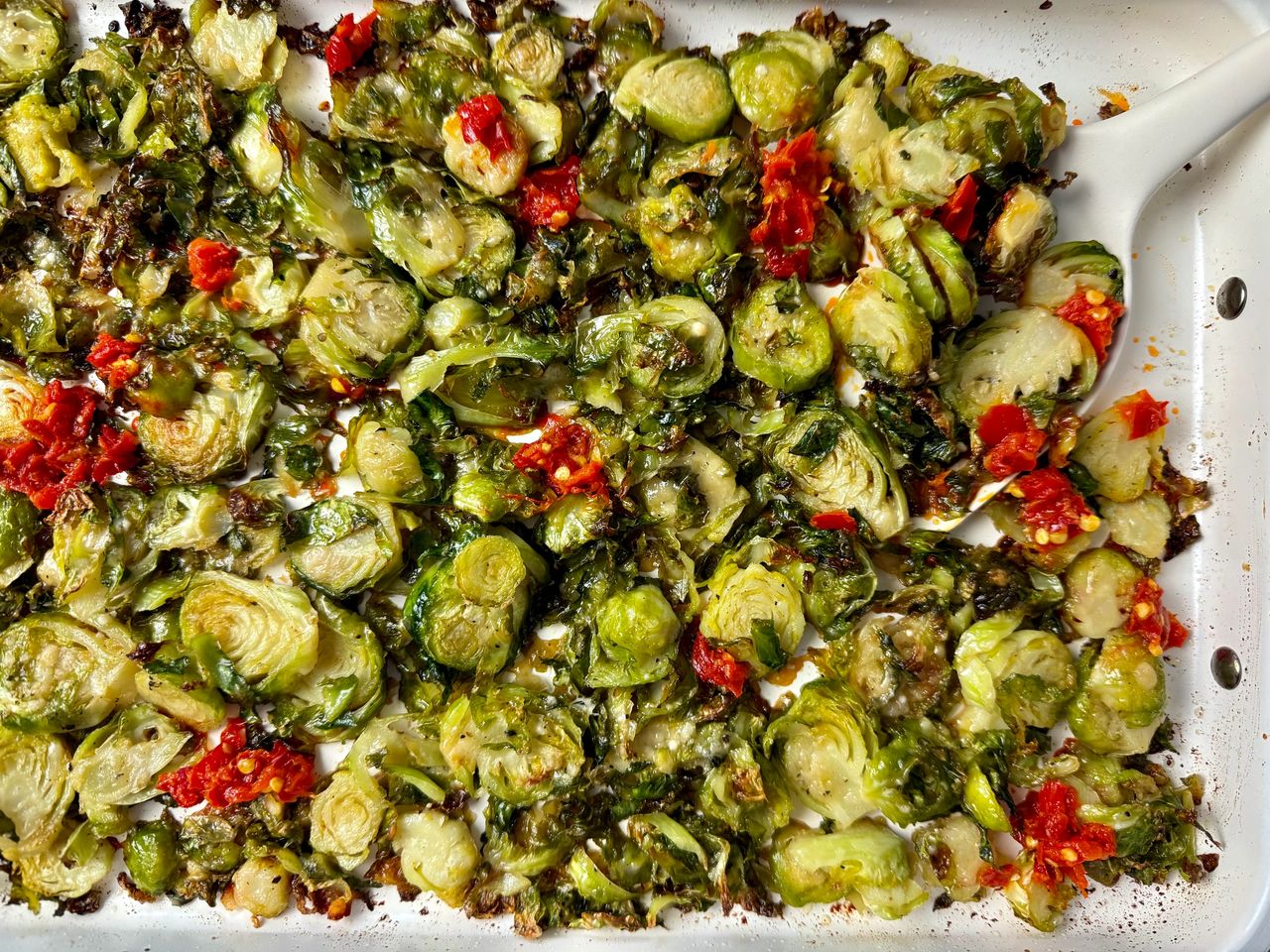 Shaved Brussels Sprouts with Calabrian Peppers on a white baking pan