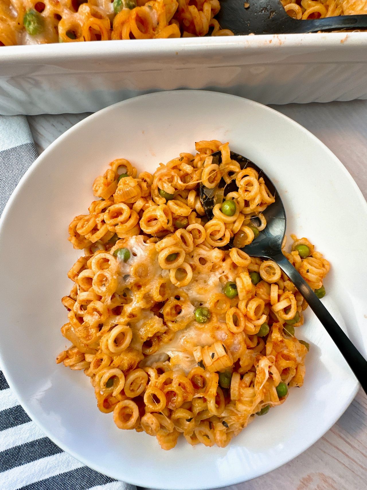 baked pasta rings with sauce and cheese on a white plate