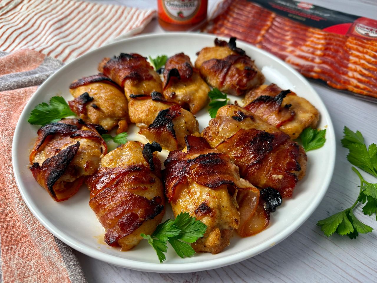 Spicy Bacon Wrapped Chicken bacon wrapped chicken on a white plate with parsley garnish