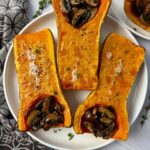butternut squash stuffed with mushrooms on a white plate