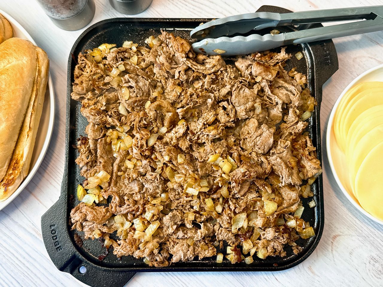 philly cheesesteak filling on a cast iron griddle