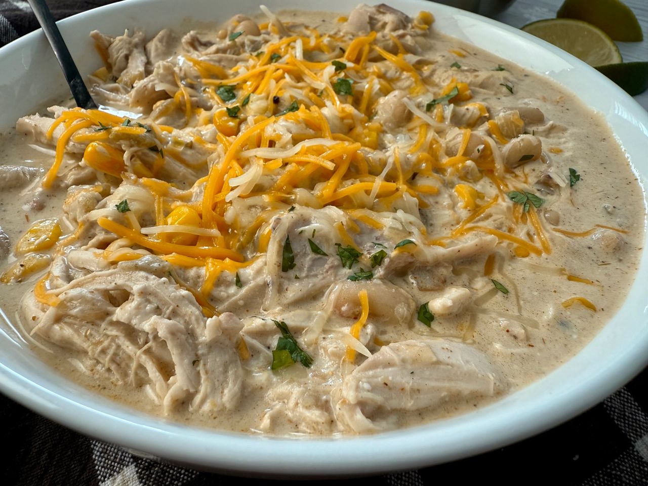 white chicken chili in a white bowl on a brown kitchen towel