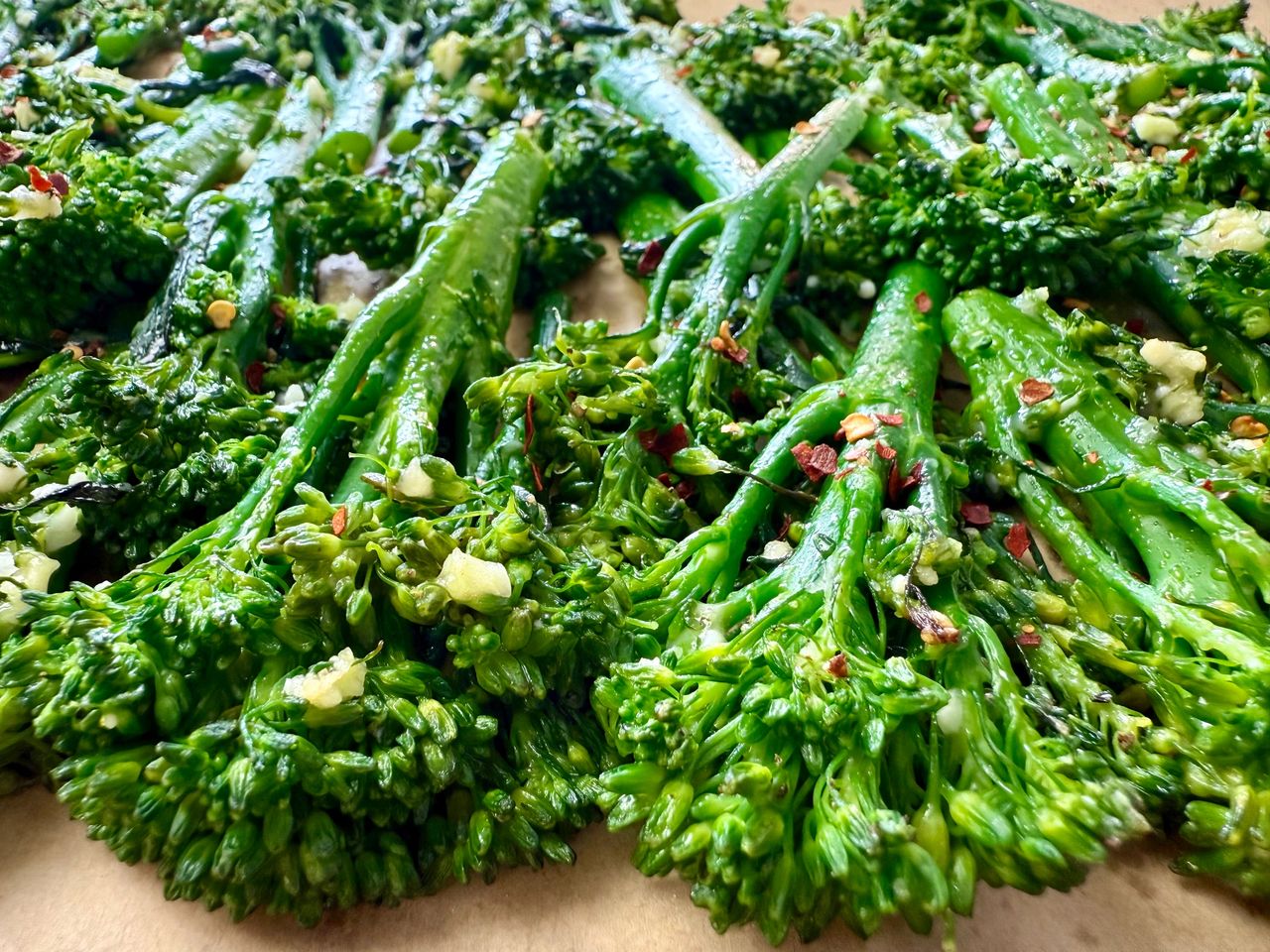 broccolini and red pepper flakes on a parchment paper lined baking sheet