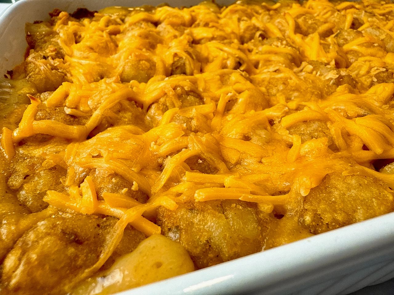 tater tot casserole in a white baking dish 