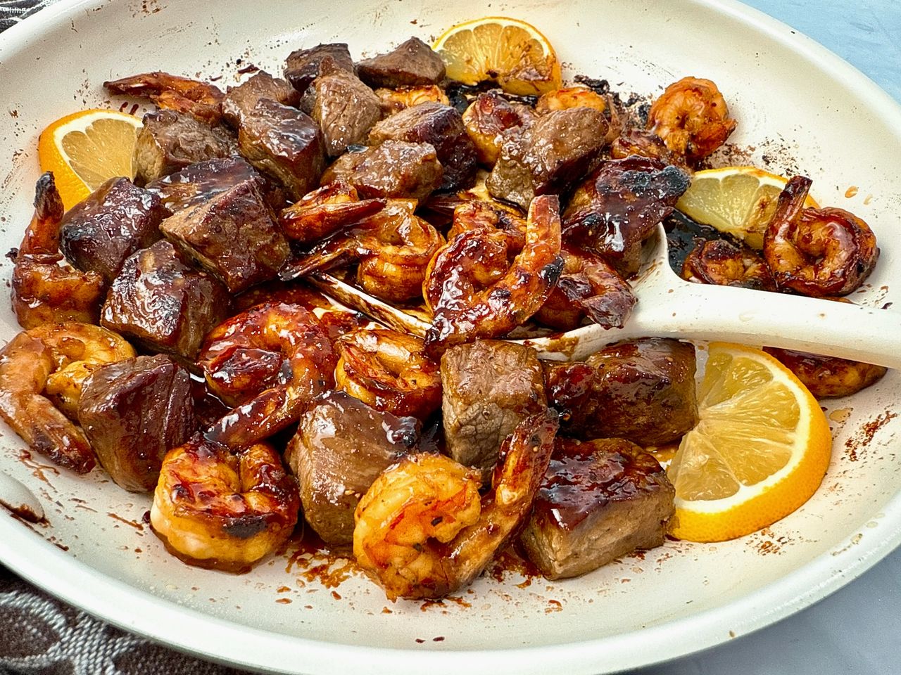 steak and shrimp in a white skillet