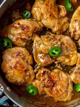 chicken thighs and jalapeno peppers in a silver pan