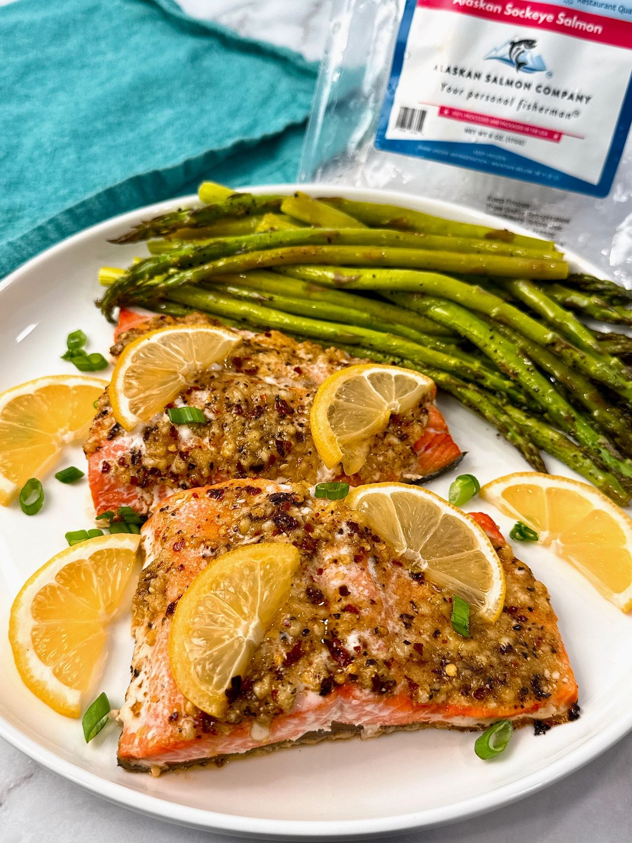salmon on a white plate with lemon slices