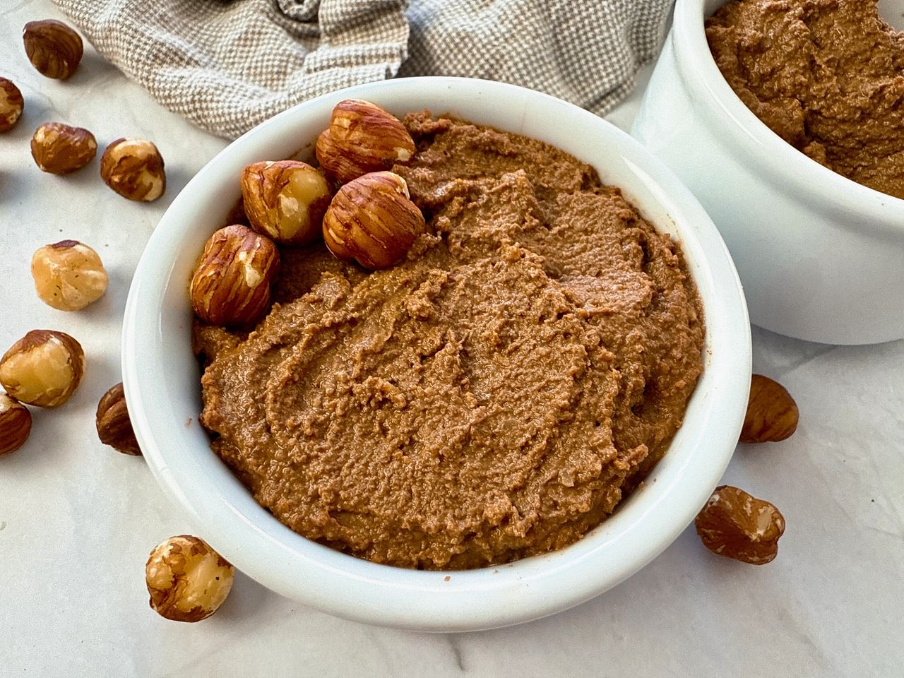 hazelnut spread in a white ramekin with a butter knife