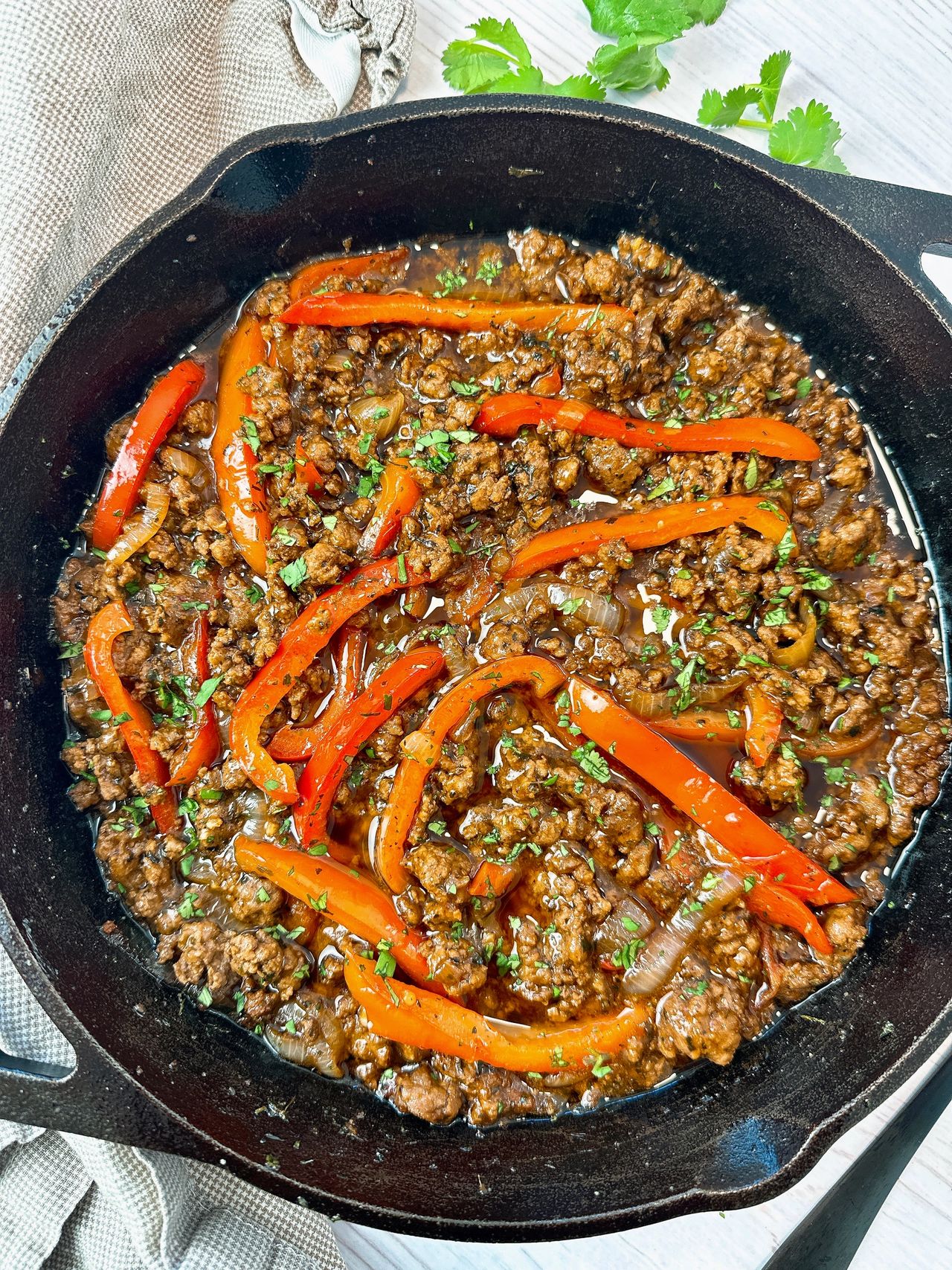 ground beef and peppers in a cast iron skillet
