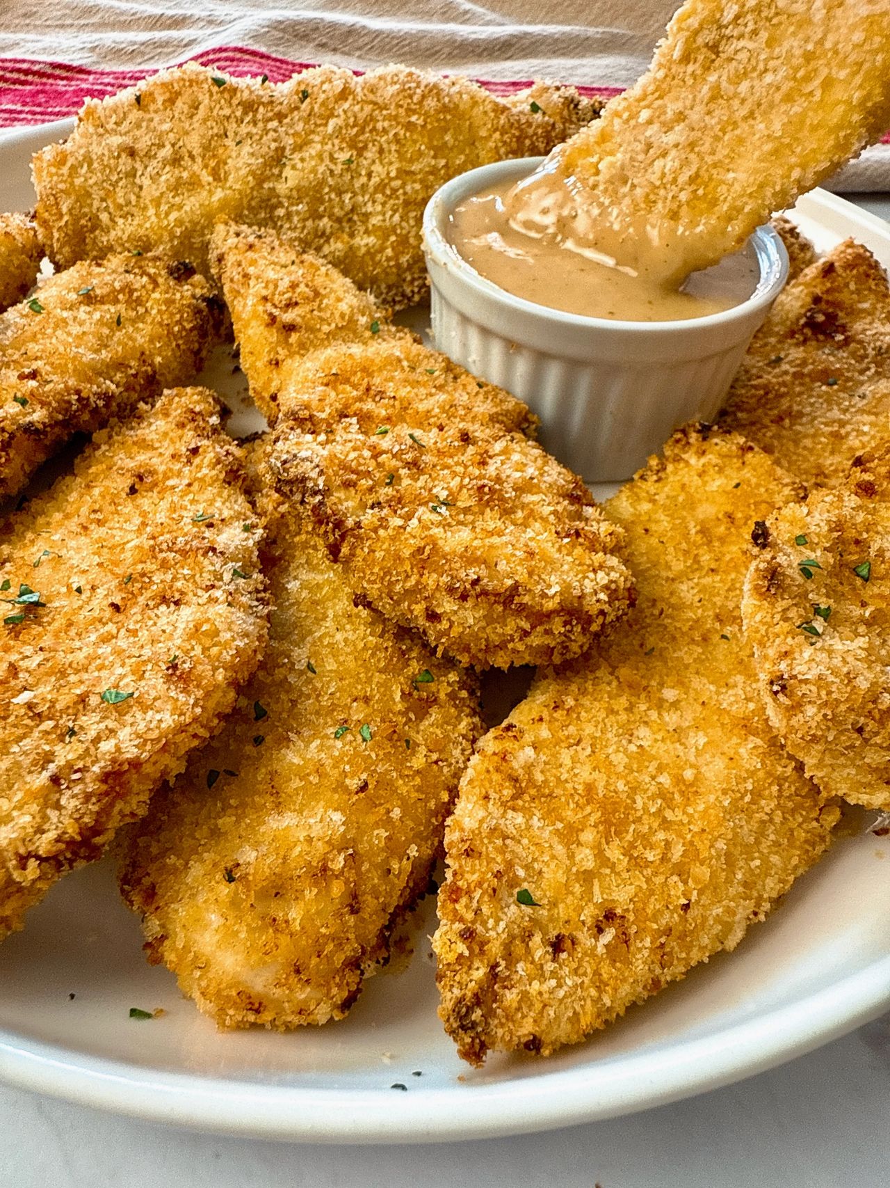 baked chicken fingers and honey mustard dip on a white plate