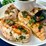 grilled chicken with chimichurri sauce on a white plate