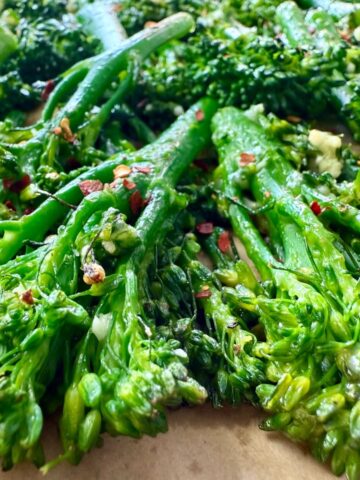 broccolini and red pepper flakes on a parchment paper lined baking sheet