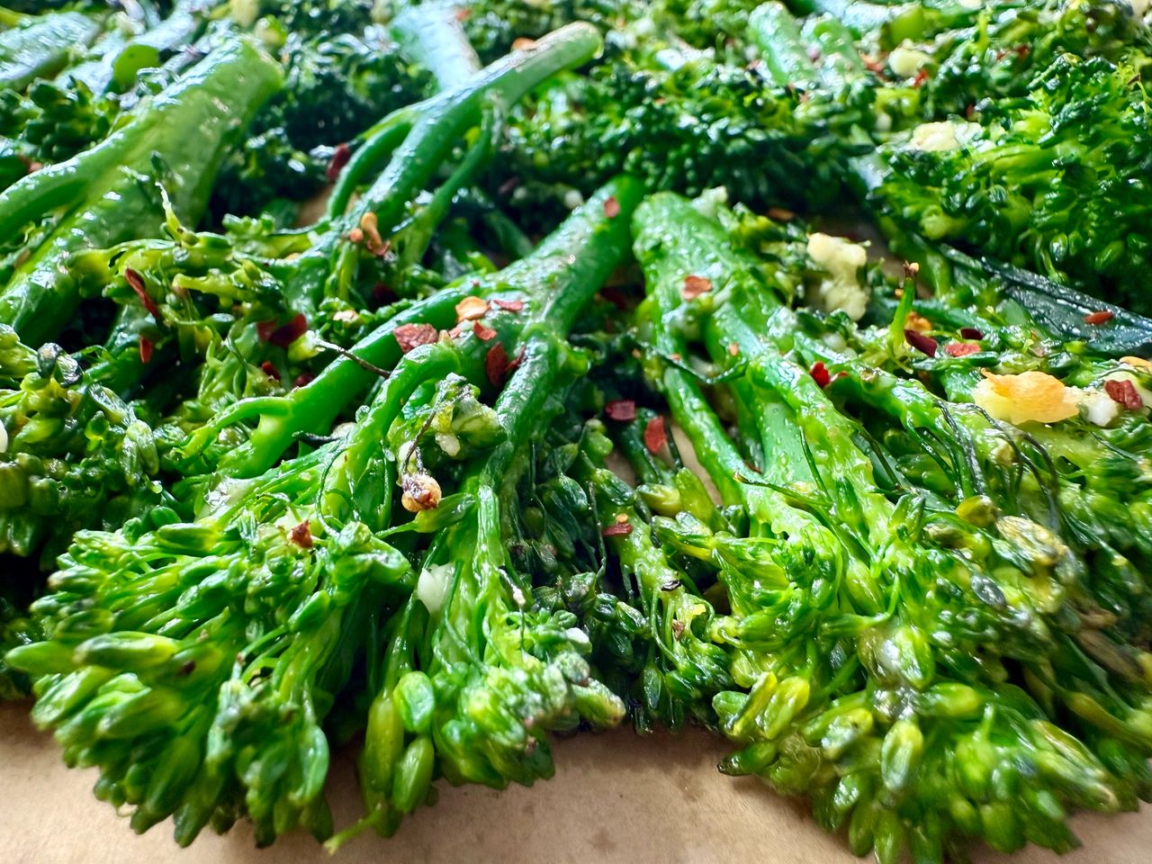 Garlic Parmesan Broccolini broccolini and red pepper flakes on a parchment paper lined baking sheet