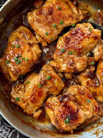 teriyaki chicken in a pan with a serving spoon