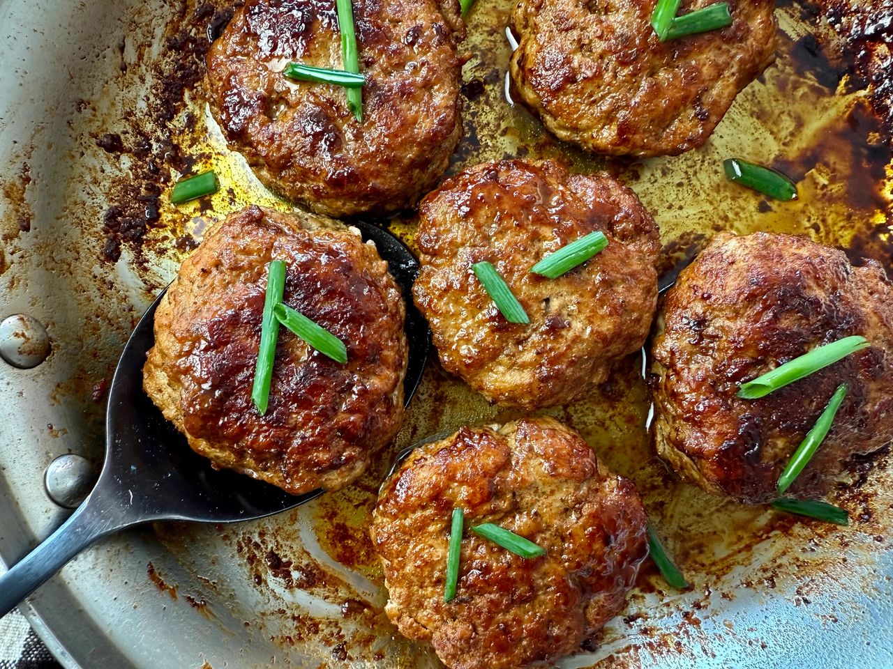Polish Sausage Patties polish sausage on a spoon in a skillet