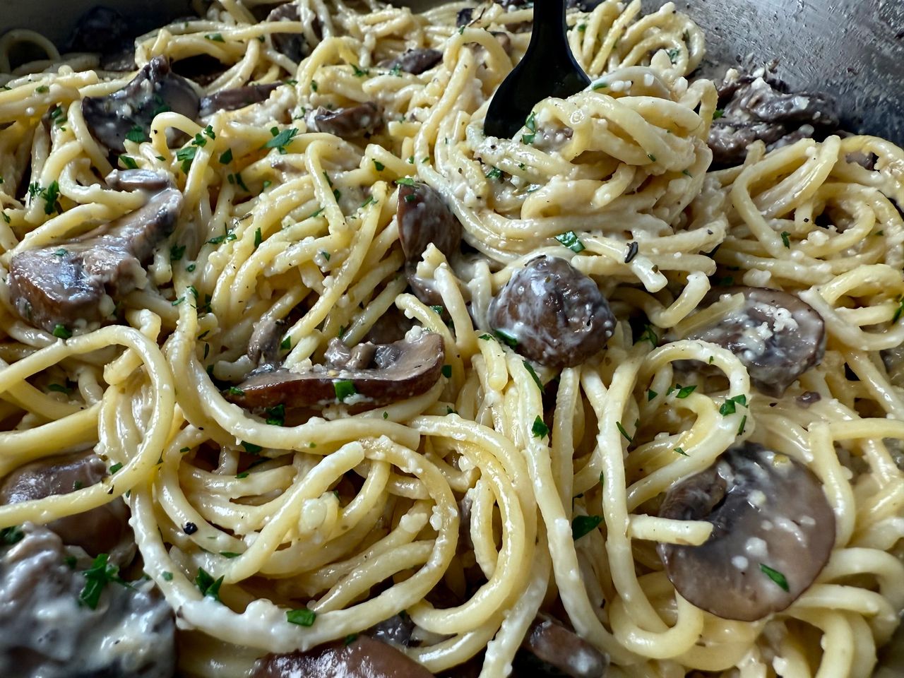 Pasta with Mushrooms in a skillet with a black fork