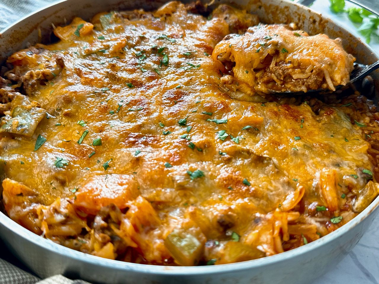 Unstuffed Peppers ground beef and rice covered with melted cheddar cheese in a deep skillet