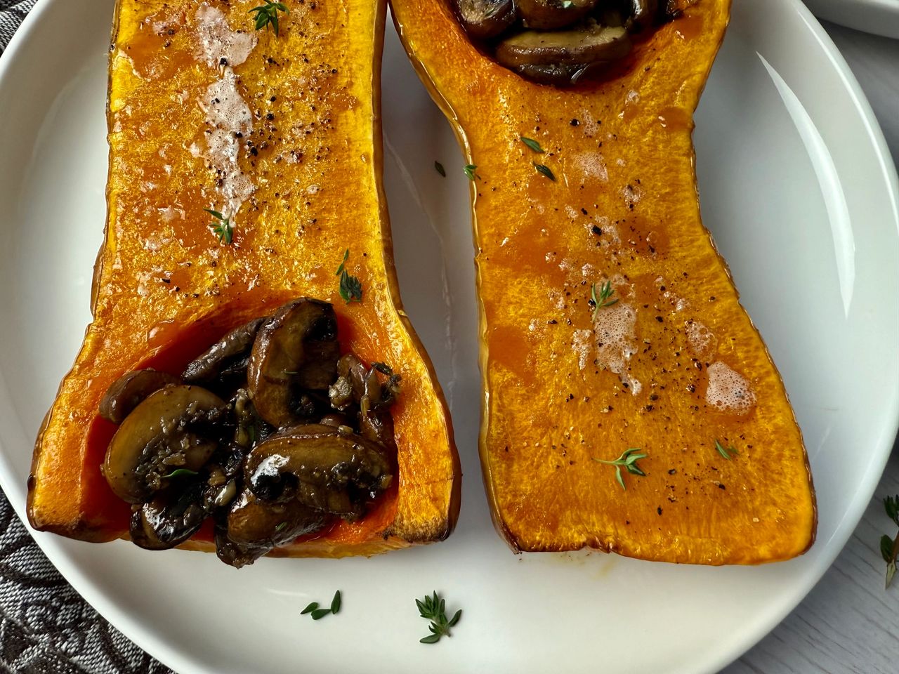 butternut squash stuffed with mushrooms on a white plate