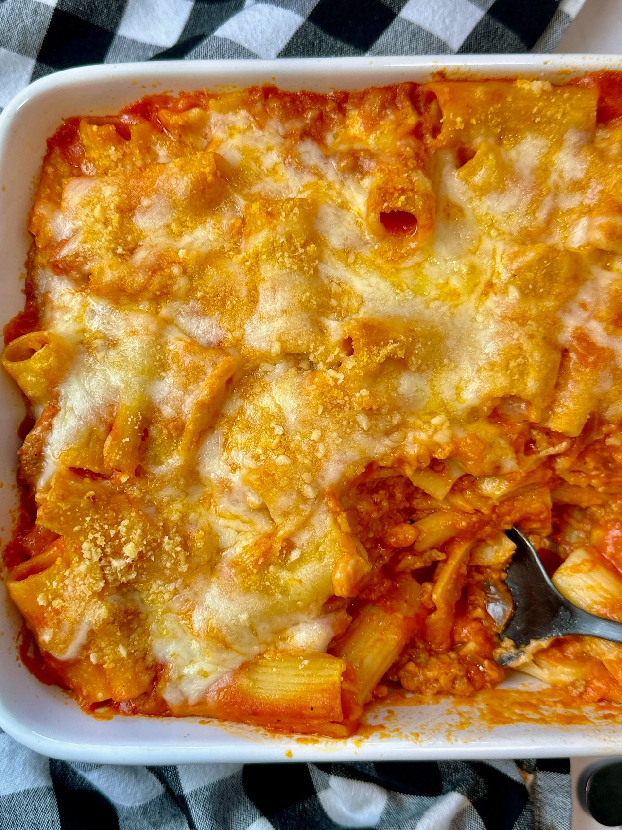 pasta and sausage in a casserole dish and white bowl